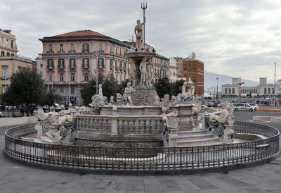 Fountain in city against sky