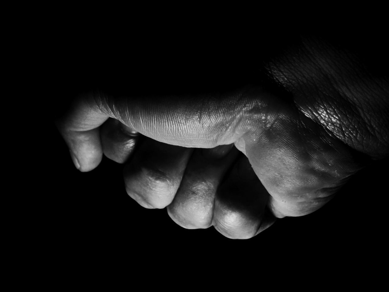 CLOSE-UP OF HANDS OVER BLACK BACKGROUND