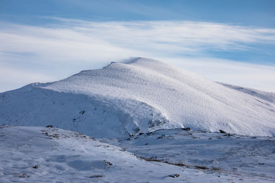 Scenic view of snow covered mountains against sky