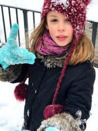 Portrait of girl standing on snow covered field during winter