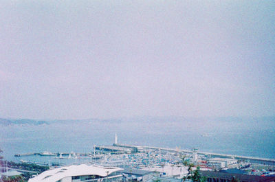 High angle view of cityscape by sea against sky