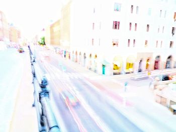 Blurred motion of vehicles on road along buildings