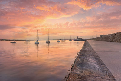 Boats on sea during sunset