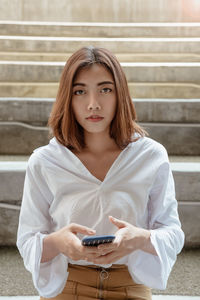 Portrait of young woman using mobile phone