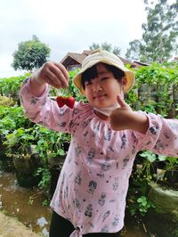 Portrait of girl standing against plants