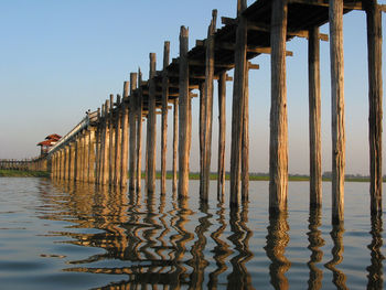 Wooden structure in sea against clear sky