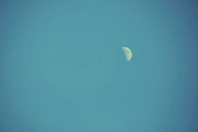 Low angle view of moon in blue sky