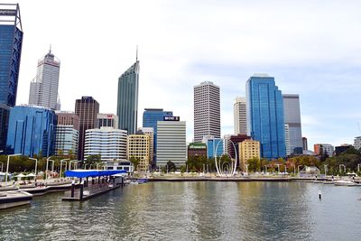 Buildings in city against cloudy sky