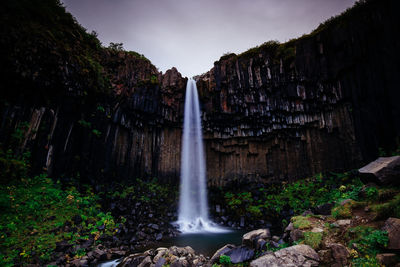 Low angle view of waterfall against sky