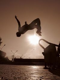 Silhouette of woman jumping in park