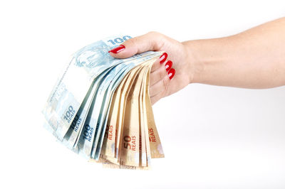 Close-up of woman holding hands over white background
