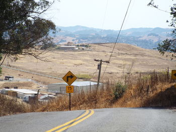Road leading towards mountains against sky