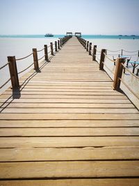 Wooden pier over sea against sky