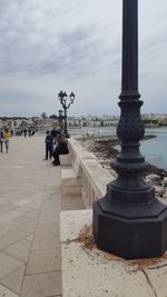 People at observation point against sky in city