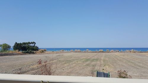 Scenic view of beach against clear blue sky