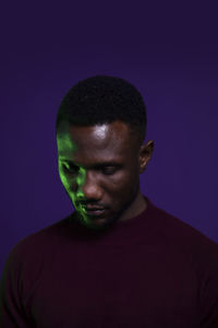 Portrait of young man against black background