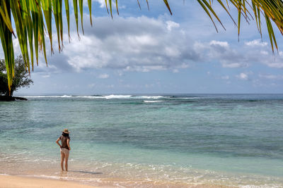 Full length of man standing on beach against sky