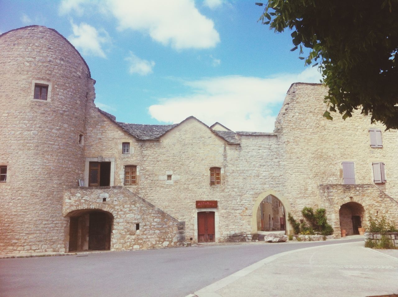 architecture, building exterior, built structure, sky, window, arch, stone wall, old, building, street, history, cloud - sky, house, residential structure, brick wall, day, wall, cloud, wall - building feature, residential building