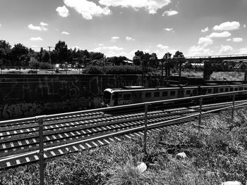 Railroad tracks by trees against sky