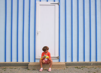 Full length of a girl sitting outdoors