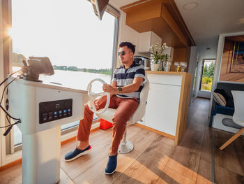 Full length of man sailing houseboat