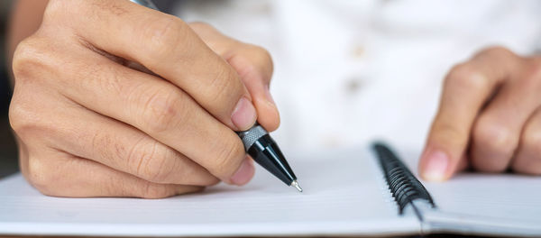 Close-up of man holding hands on table