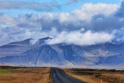 Road leading towards rocky mountain