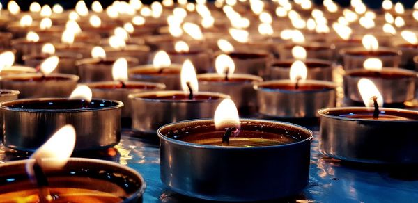 Close-up of lit tea light candles in temple