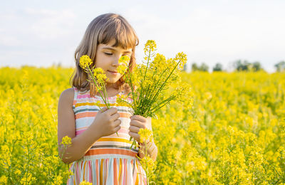 Girl smelling flowers in field