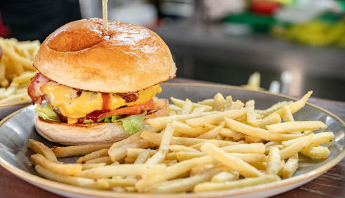 A freshly grilled beef cheese burger served alongside a portion of french fries