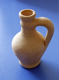 Close-up of vase over blue background