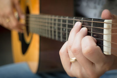 Close-up of hands playing guitar