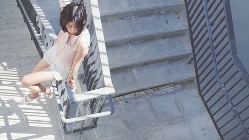 Full length of young woman walking on stairs
