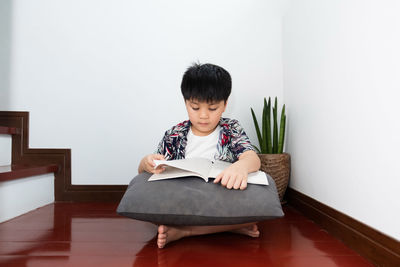 Portrait of boy sitting on floor at home