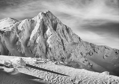 Scenic view of snowcapped mountains against blue sky