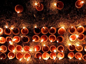 Directly above shot of diyas burning on grass