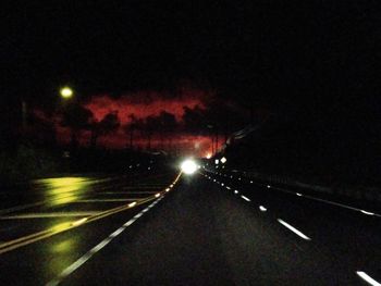 Illuminated street lights on road at night