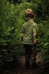 Rear view of boy standing on field