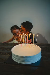 Colourful candles on white cake. children celebrating birthdays together.