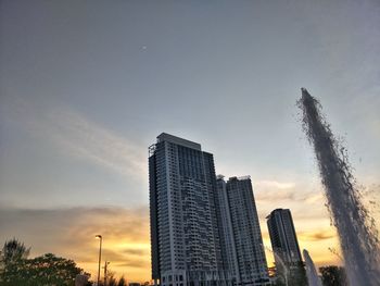 Low angle view of modern buildings against sky during sunset