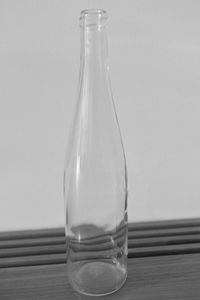 Close-up of empty glass on table against white background
