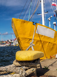 Sailboats moored on harbor by sea against sky