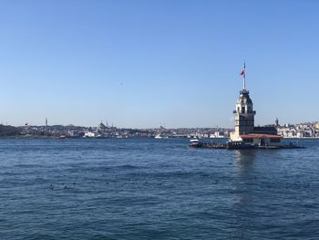 View of buildings in city against clear blue sky