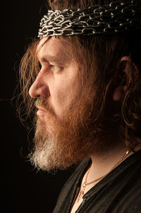 Close-up of man looking away against black background