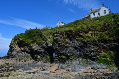 Low angle view of rock amidst buildings against sky