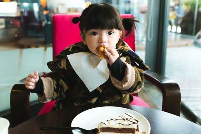 Portrait of girl eating food in restaurant