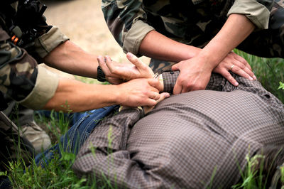 Midsection of army men arresting criminal