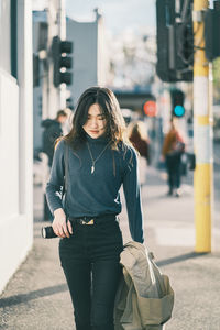 Portrait of young asian girl standing in city
