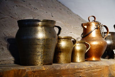 Close-up of old glass jar on table against wall