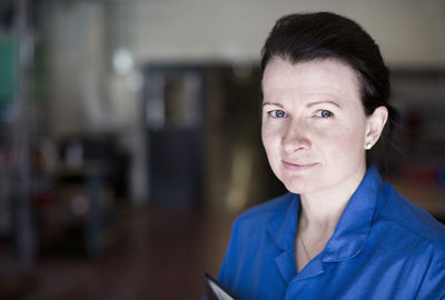 Portrait of confident female electrician in factory